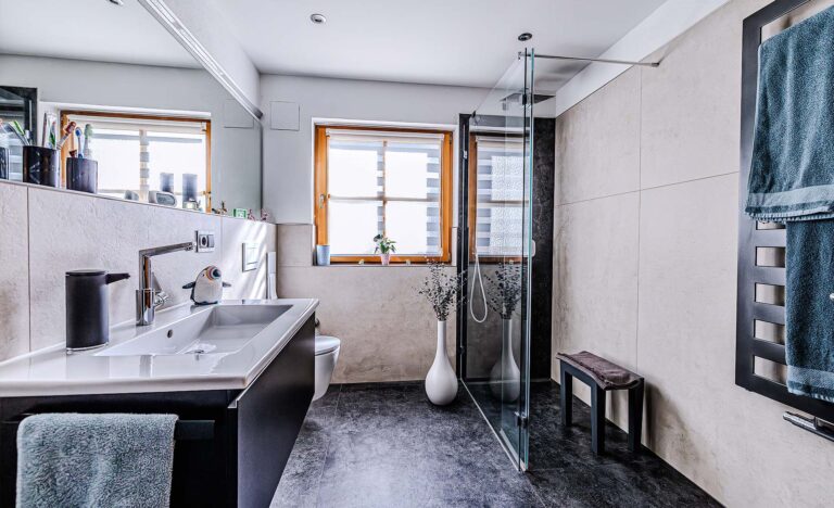 Bad mit Großformatfliesen und bodengleicher Dusche